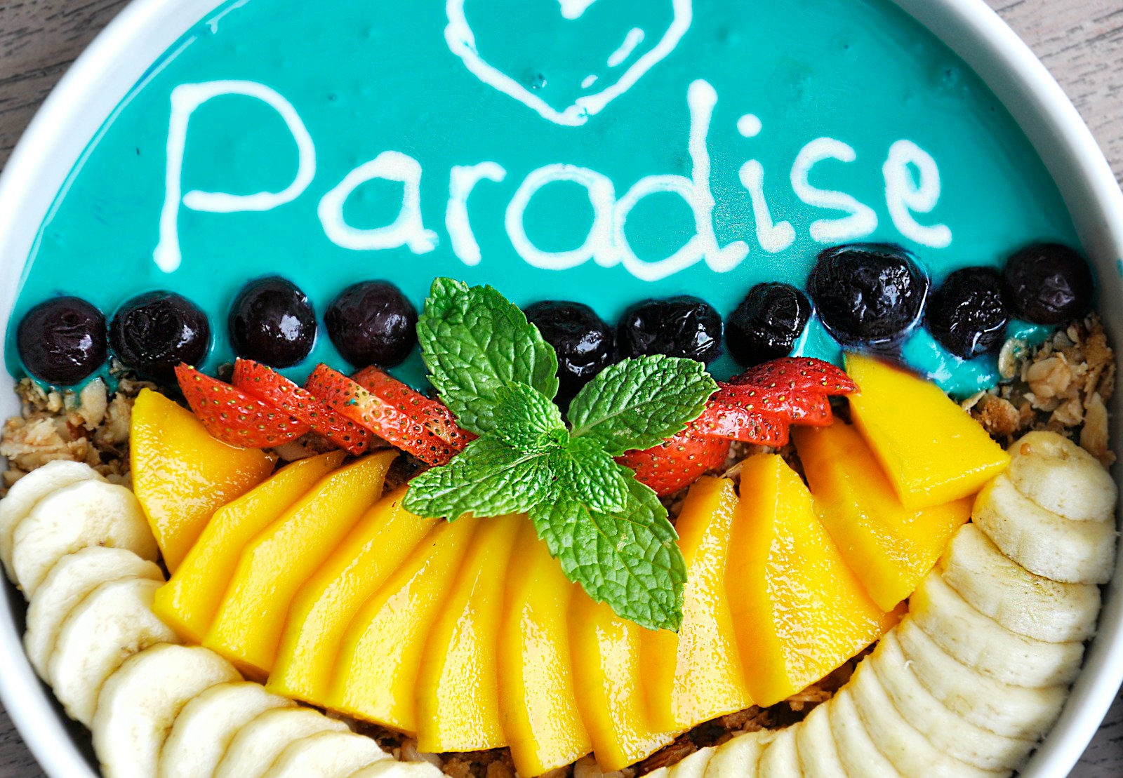 variety of sliced fruits on top of white and teal container