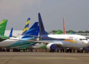 Multiple commercial airplanes parked on an airport runway.